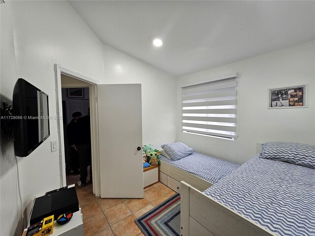 bedroom with light tile patterned flooring and vaulted ceiling