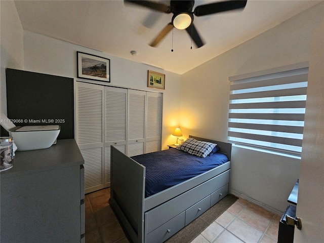 tiled bedroom with ceiling fan and a closet