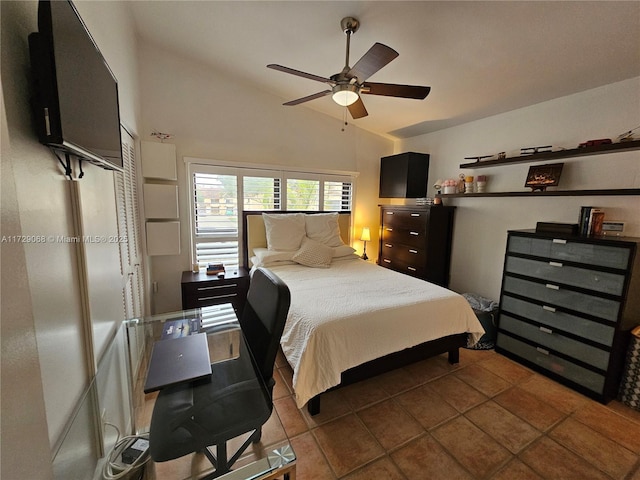 bedroom featuring dark tile patterned floors, vaulted ceiling, and ceiling fan