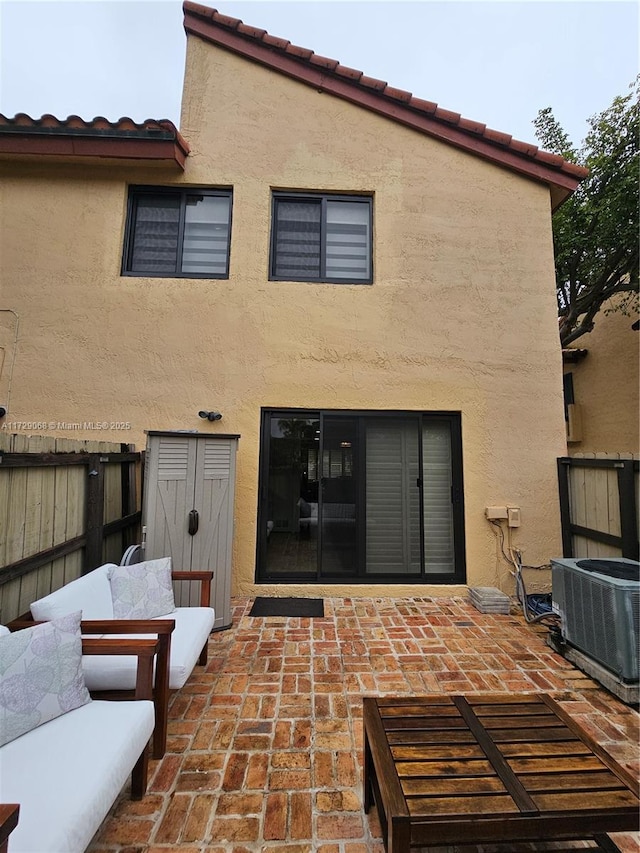 rear view of property with a patio and central AC