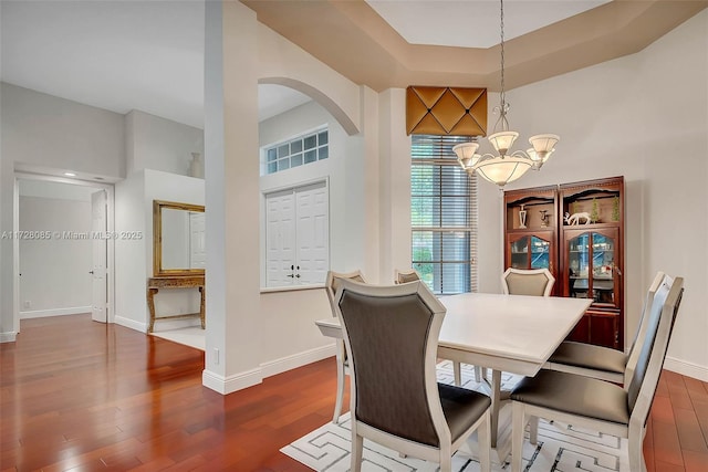 dining area with dark hardwood / wood-style floors and a chandelier