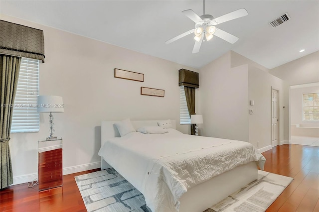 bedroom featuring multiple windows, hardwood / wood-style floors, and ceiling fan