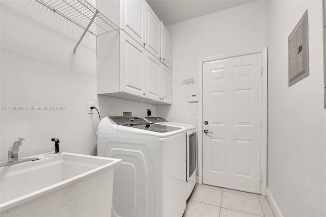 washroom featuring sink, cabinets, light tile patterned floors, electric panel, and washer and clothes dryer