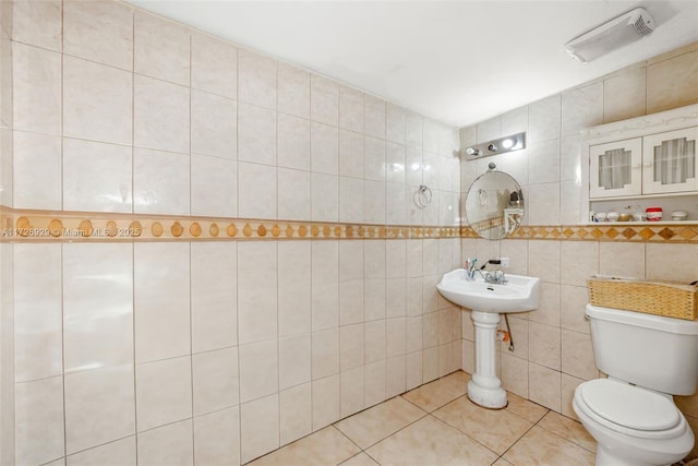 bathroom with tile patterned floors, tile walls, and toilet