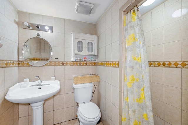 bathroom with tile walls, toilet, and a shower with shower curtain