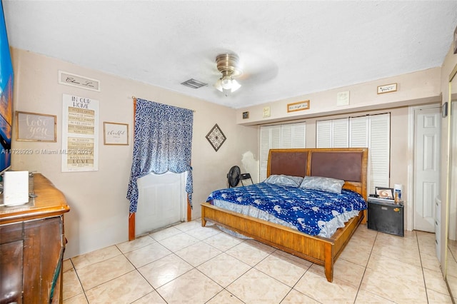 tiled bedroom featuring a textured ceiling and ceiling fan