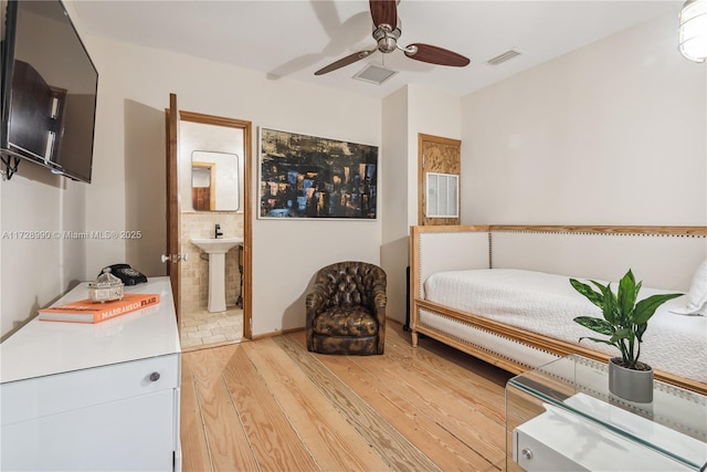 bedroom featuring connected bathroom, light wood-style flooring, ceiling fan, a sink, and visible vents