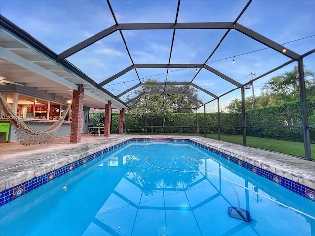 view of swimming pool featuring a patio and glass enclosure