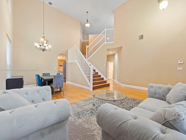 living area with stairway, baseboards, and wood finished floors