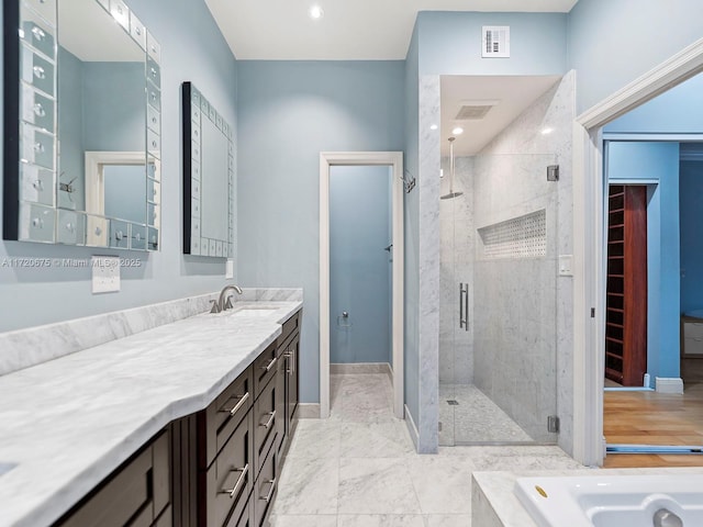 bathroom featuring visible vents, baseboards, a shower stall, and vanity