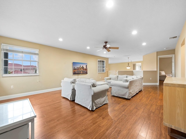 living room featuring recessed lighting, wood finished floors, visible vents, baseboards, and a wealth of natural light