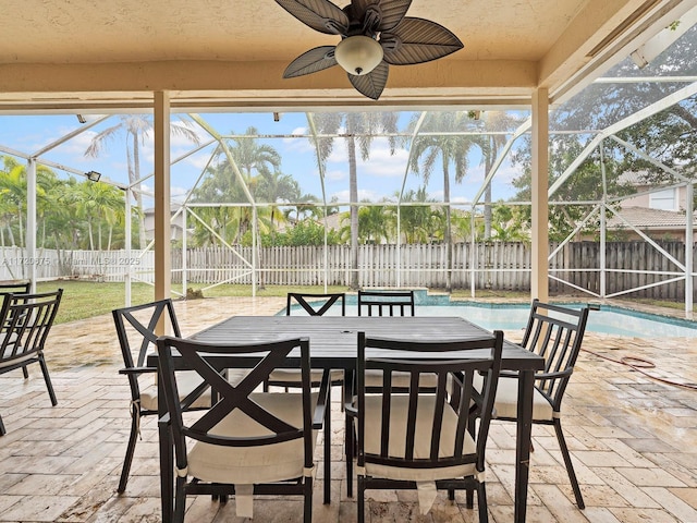 view of patio featuring a fenced in pool, glass enclosure, a fenced backyard, ceiling fan, and outdoor dining space