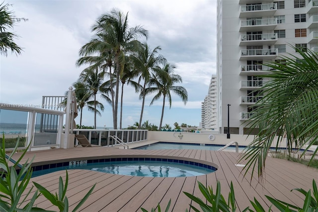 view of pool featuring a community hot tub and a water view