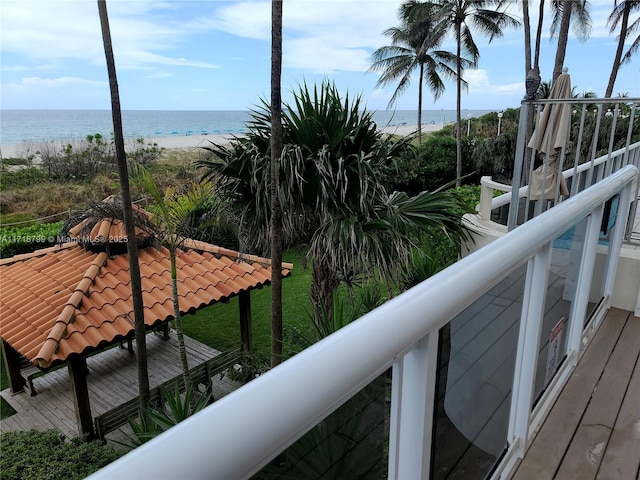 balcony with a water view and a beach view