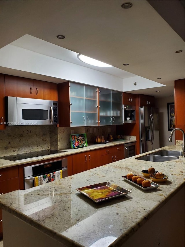 kitchen featuring wine cooler, decorative backsplash, sink, light stone countertops, and stainless steel appliances