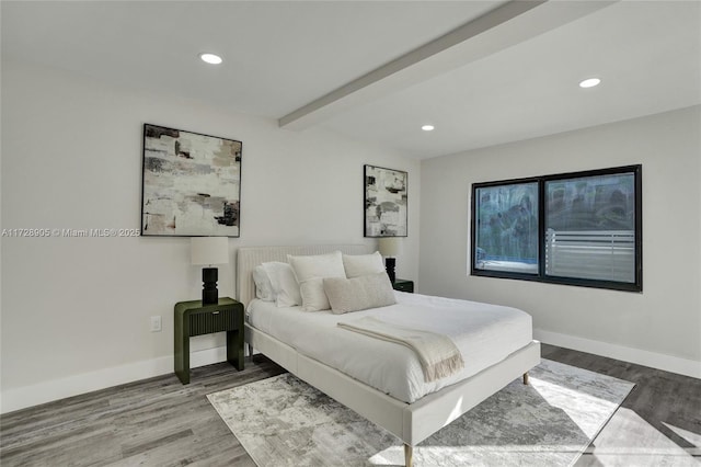 bedroom featuring hardwood / wood-style flooring and beamed ceiling