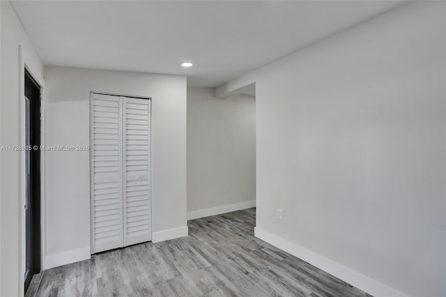 unfurnished bedroom with a closet and light wood-type flooring