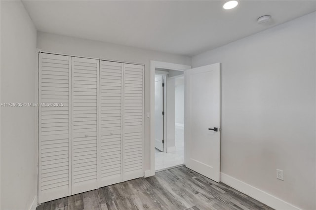 unfurnished bedroom with a closet and light hardwood / wood-style floors