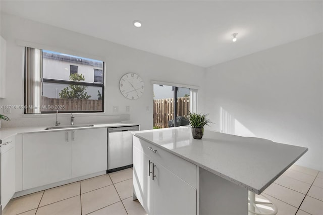 kitchen with sink, white cabinetry, stainless steel dishwasher, and a kitchen island