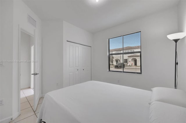 tiled bedroom featuring a closet