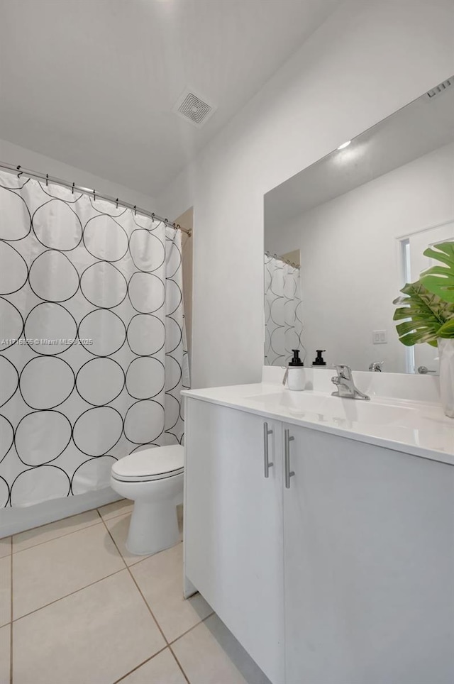 bathroom featuring toilet, walk in shower, tile patterned floors, and vanity