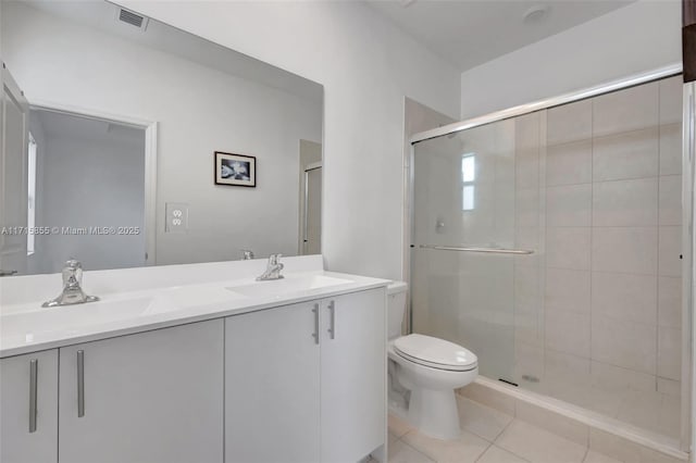 bathroom featuring toilet, tile patterned flooring, a shower with shower door, and vanity