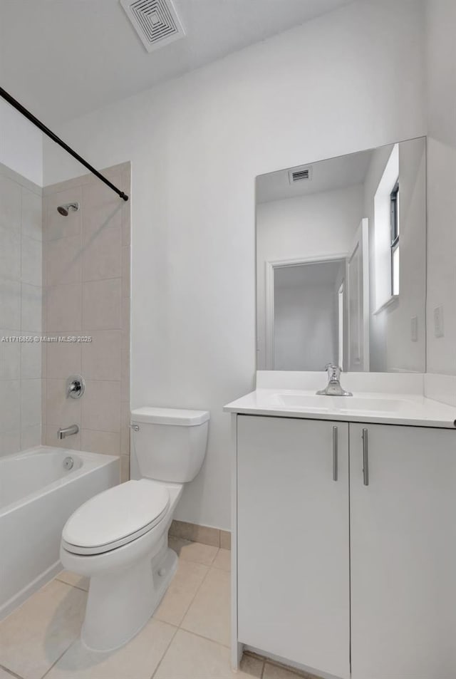 full bathroom with toilet, tile patterned flooring, tiled shower / bath, and vanity