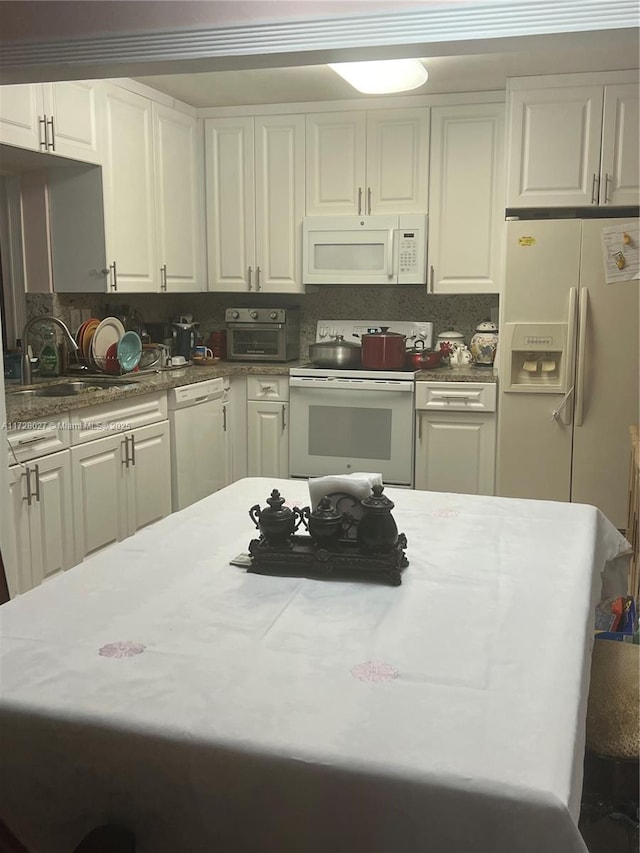 kitchen with sink, white appliances, white cabinetry, and decorative backsplash