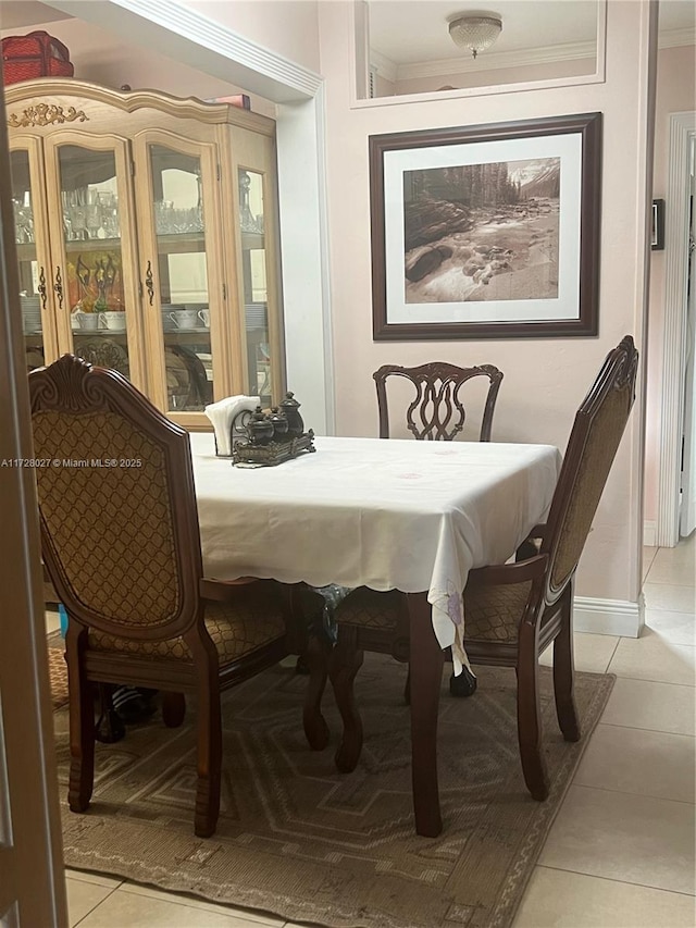 dining space featuring crown molding and light tile patterned floors