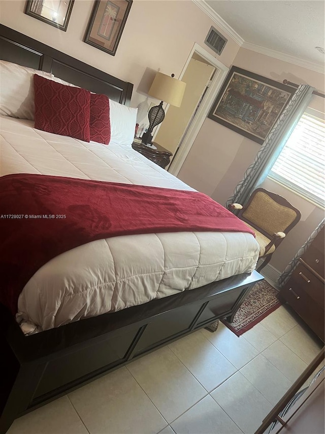 bedroom with light tile patterned flooring and ornamental molding