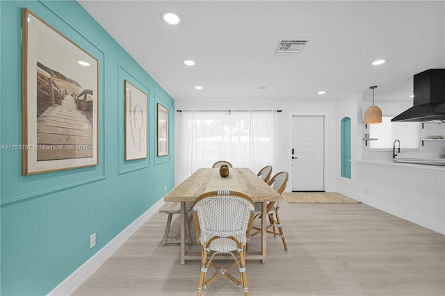 dining room with light wood-type flooring and a wealth of natural light