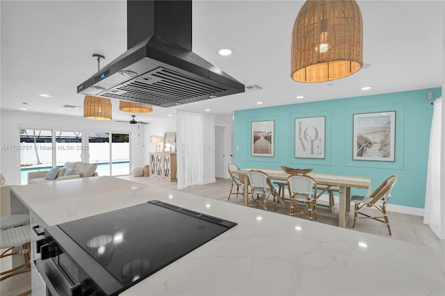 kitchen with hanging light fixtures, range with electric cooktop, island range hood, and light stone counters