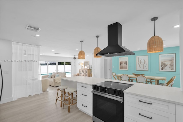 kitchen featuring hanging light fixtures, range with electric cooktop, extractor fan, light hardwood / wood-style floors, and white cabinets