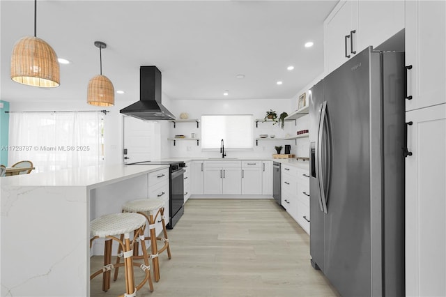 kitchen featuring light stone counters, white cabinets, stainless steel appliances, and island range hood