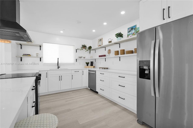 kitchen featuring extractor fan, white cabinetry, sink, stainless steel appliances, and light hardwood / wood-style flooring