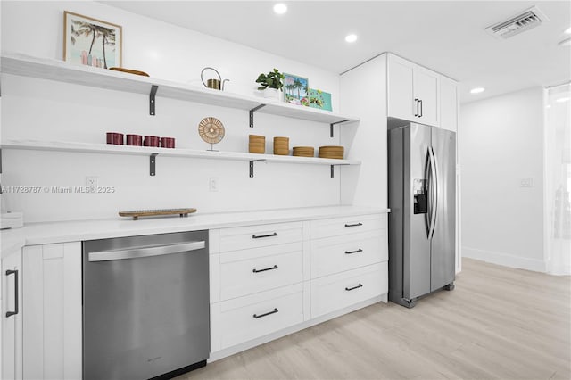 kitchen featuring white cabinetry, light hardwood / wood-style floors, and appliances with stainless steel finishes