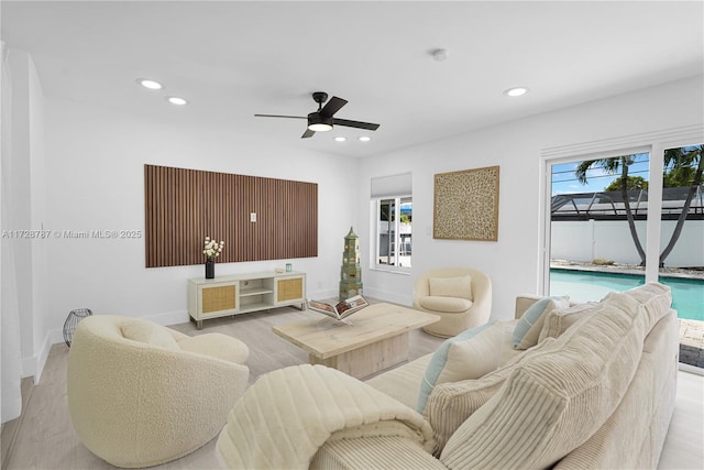 living room featuring light wood-type flooring and ceiling fan