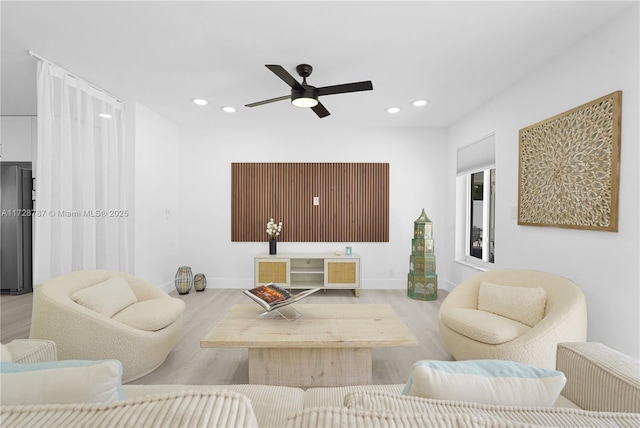 living room featuring ceiling fan and light hardwood / wood-style floors