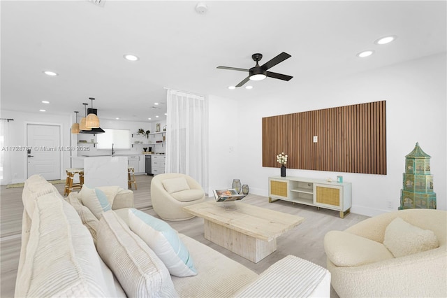 living room featuring ceiling fan and light hardwood / wood-style flooring