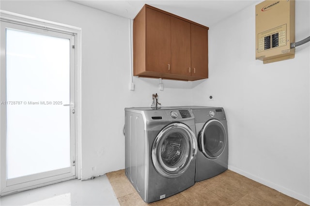 laundry area with cabinets, washing machine and dryer, and electric panel