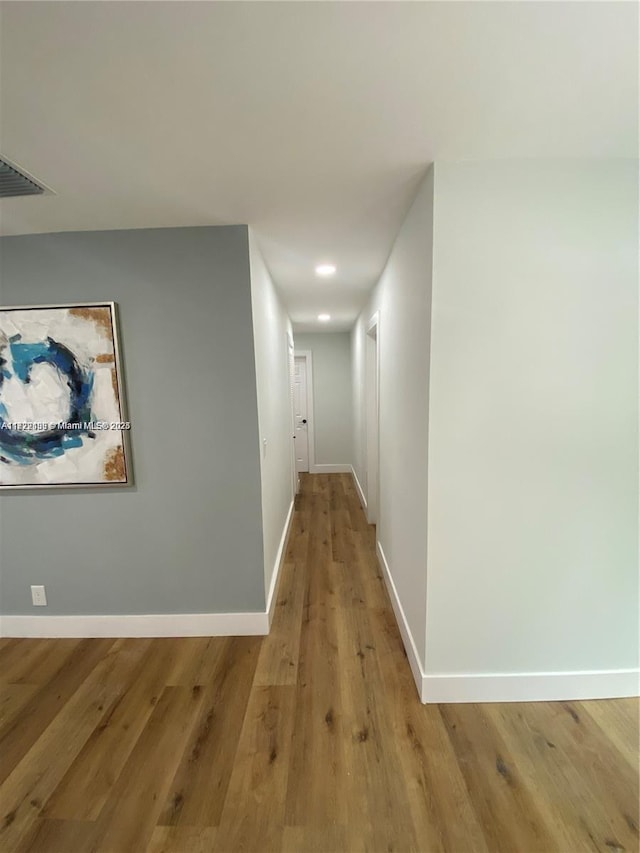 hallway with hardwood / wood-style flooring