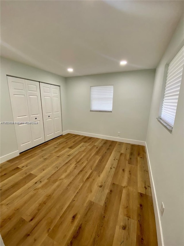 unfurnished bedroom featuring a closet and light wood-type flooring