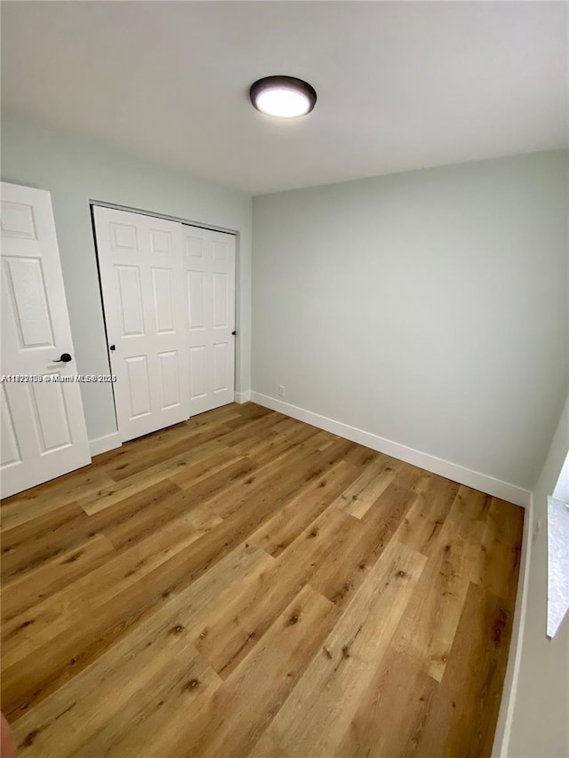 unfurnished bedroom with a closet and hardwood / wood-style flooring