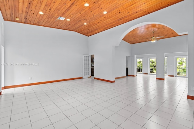 tiled empty room featuring wooden ceiling, high vaulted ceiling, and ceiling fan