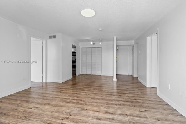 interior space featuring a textured ceiling and light hardwood / wood-style flooring