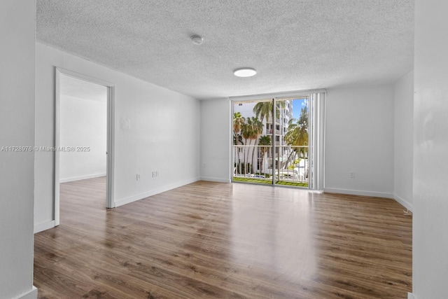 spare room featuring hardwood / wood-style floors and expansive windows