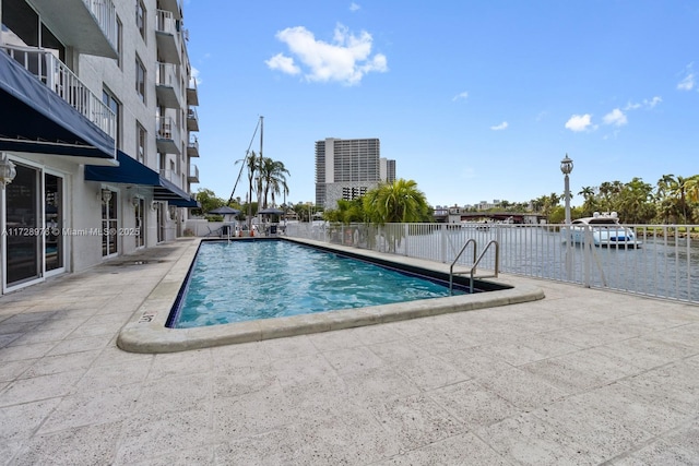 view of pool with a water view and a patio