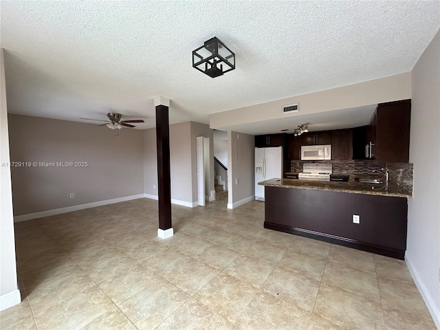 kitchen featuring white appliances, sink, backsplash, kitchen peninsula, and dark brown cabinets