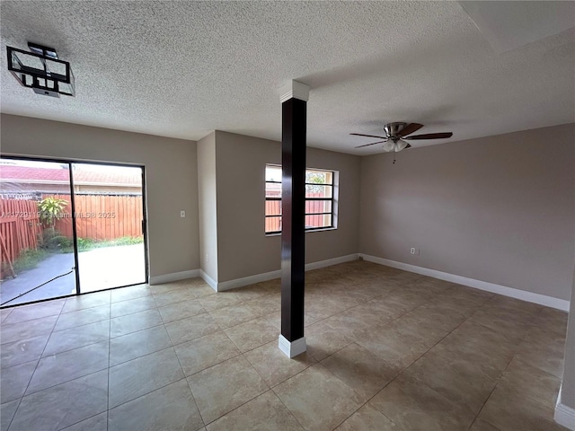 empty room with a textured ceiling, ceiling fan, and light tile patterned floors