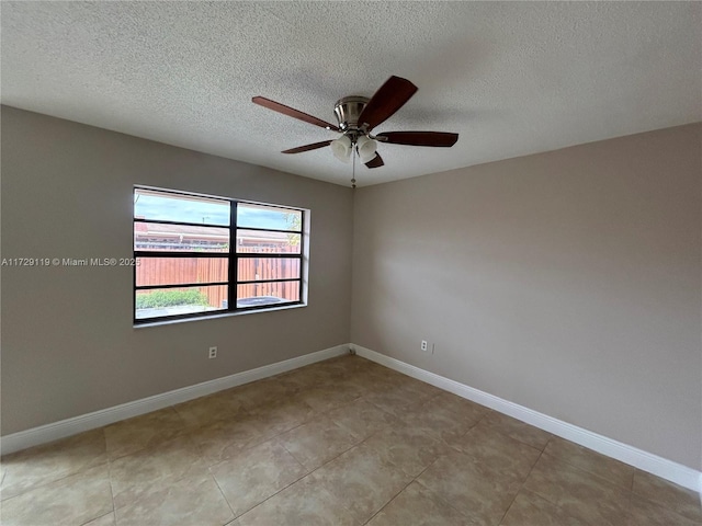 empty room featuring ceiling fan, light tile patterned flooring, and a textured ceiling